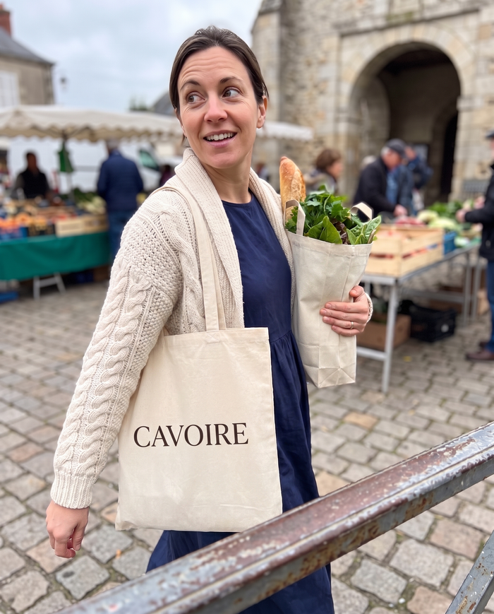 Femme en cardigan crème torsadé au marché du village